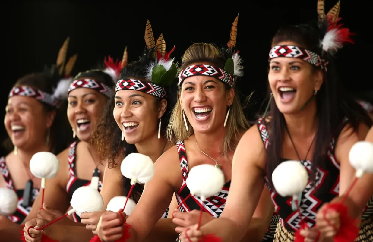 Happy New Zealand women in tradition Maori dress